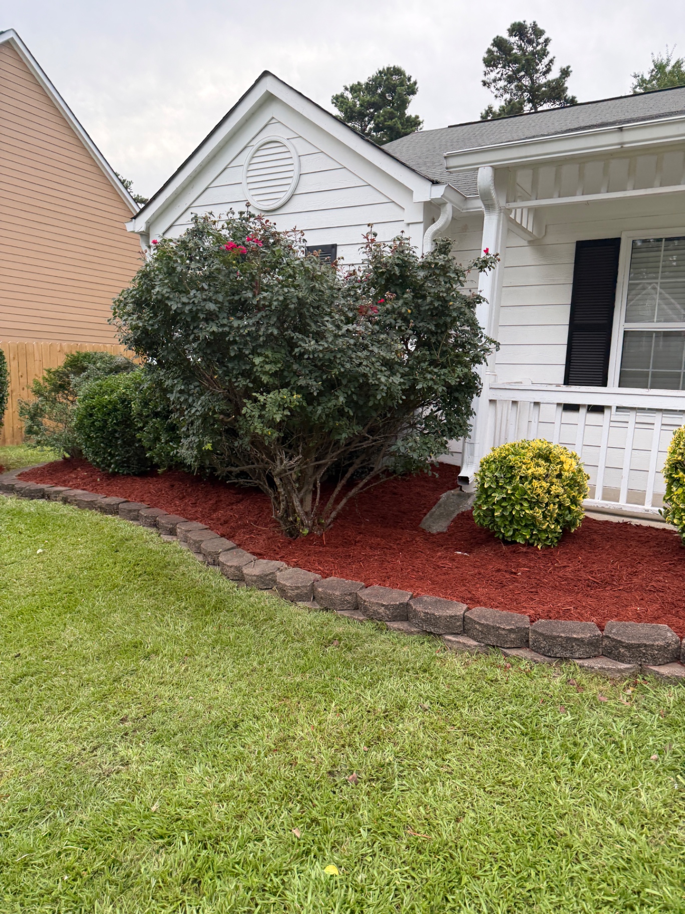 Front landscape bed with stone border and fresh red mulch