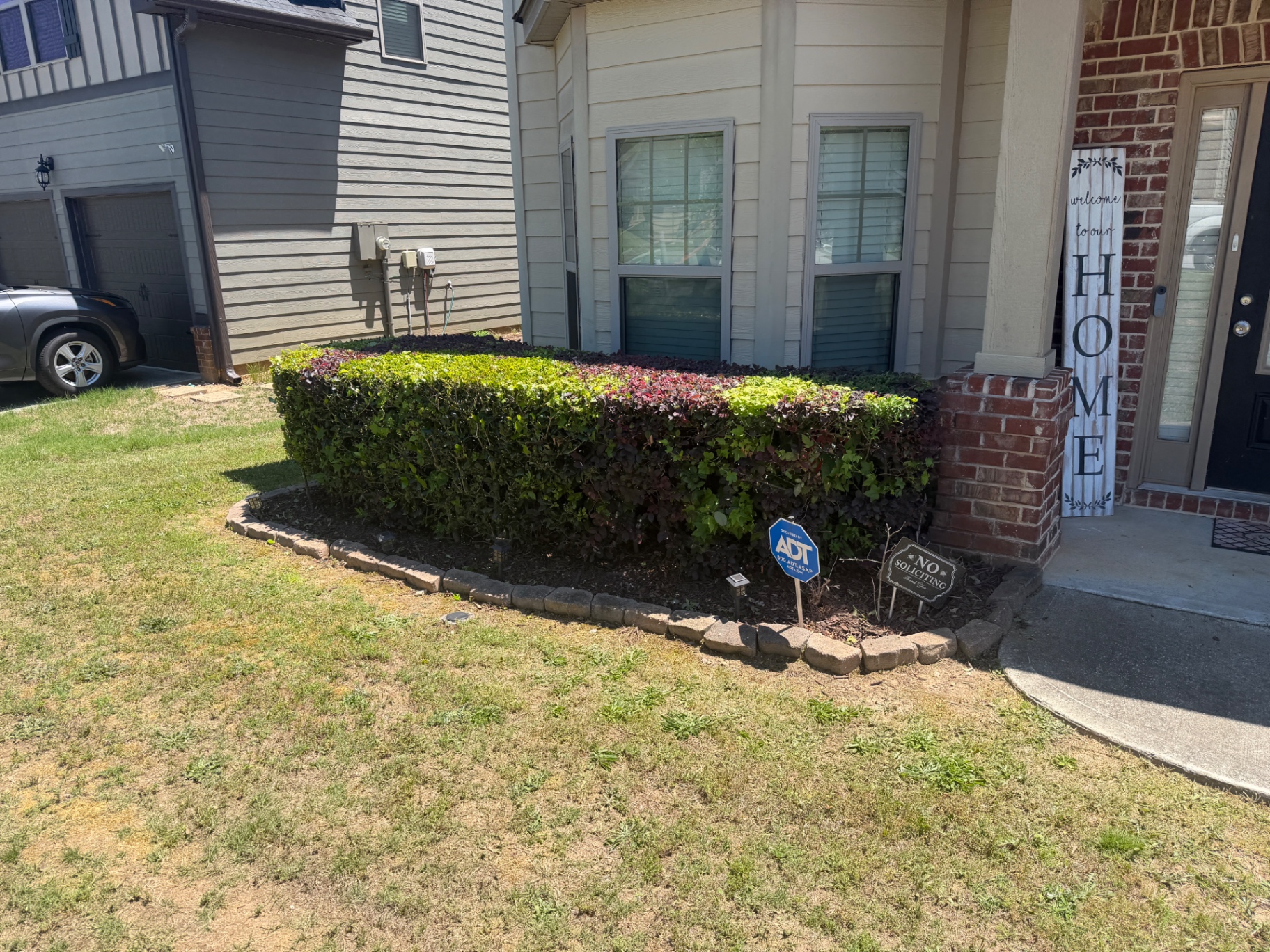 Front-yard hedge bed before maintenance in Douglasville, GA
